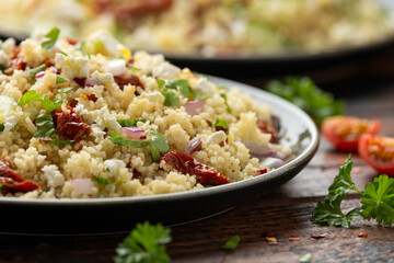 Couscous salad with sun dried tomatoes, cucumber, red onion and feta cheese. healthy food.