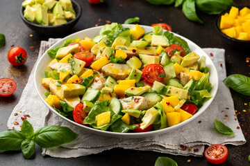 Tasty Chicken mango salad with avocado, cucumber, cherry tomatoes. Healthy food