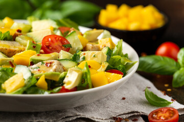 Tasty Chicken mango salad with avocado, cucumber, cherry tomatoes. Healthy food