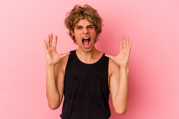 Young caucasian man with make up isolated on pink background screaming to the sky, looking up, frustrated.