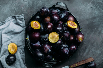Ripe blue plums on a dark background