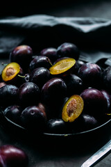 Ripe blue plums on a dark background