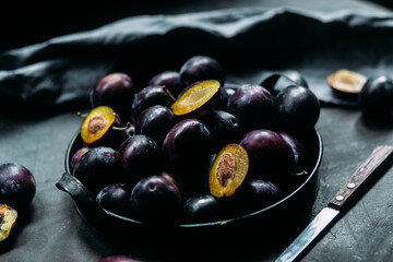 Ripe blue plums on a dark background