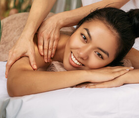 Fototapeta na wymiar Body massage to positive pretty woman enjoying rest at spa