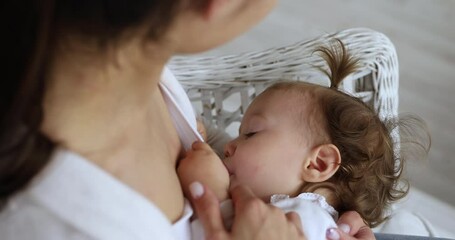 Adorable baby girl drinking mommy breast milk, enjoy moment of closeness, receive care and nutrition. Loving mother breastfeeding daughter, close up. Healthcare, immunity, infancy, babyhood concept