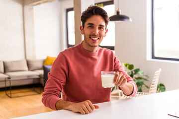 Fototapeta na wymiar Young mixed race man drinking milk for breakfast