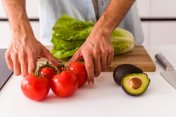 Young mixed race man preparing a salad for lunch