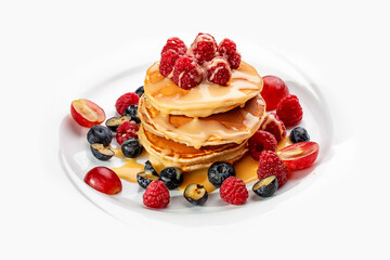 Pancakes with caramel and seasonal berries on a white background. Breakfast