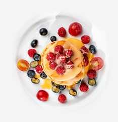 Pancakes with caramel and seasonal berries on a white background. Breakfast