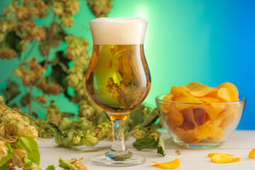 Pouring beer in tulip glass colorful background