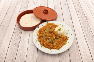 Dish with stew to make chicken tinga tacos with white rice and hot wheat tortillas to roll them