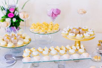 Fototapeta na wymiar Luxurious candy bar at a golden wedding. Sweets are decorated wi