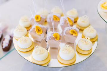 Luxurious candy bar at a golden wedding. Sweets are decorated with fruits on the background of a festive table with desserts.