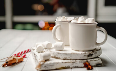 Mugs with cocoa standing beside marshmallow
