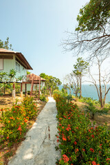Fototapeta na wymiar Stilt bungalows surrounded by trees and flowers on the edge of the Andaman Sea