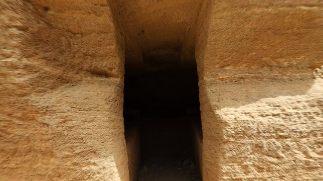 Walking through POV entering an Etruscan tomb. Etruscan Necropolis of the Caves - Populonia. Archaeological Park of Baratti and Populonia. Tuscany - Italy