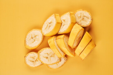 Sliced bananas on yellow background close up, healthy dessert ingredient