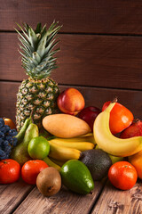 Mix of fresh juicy colorful exotic tropical fruits on wooden background