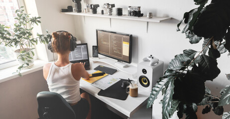 Girl programmer in the modern developer workplace for writing code with white computer desktop and...