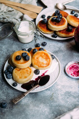 cheesecakes with berries and sauce on a gray background