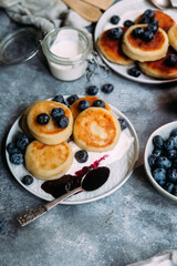 cheesecakes with berries and sauce on a gray background