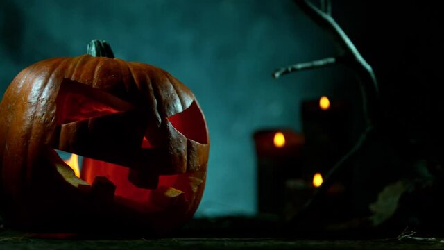 Scary Pumpkin Jack O Lantern with Flaring Candles. Halloween Background. Super Slow Motion Filmed on High Speed Cinema Camera at 1000 fps.