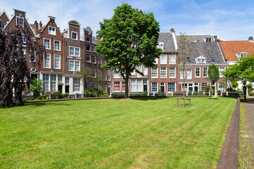 Historic houses in the Begijnhof, one of the oldest courtyards (hofjes) in Amsterdam. - obrazy, fototapety, plakaty