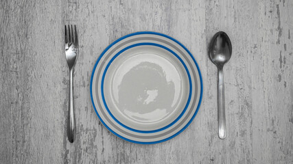 Plate with fork and spoon on white background.