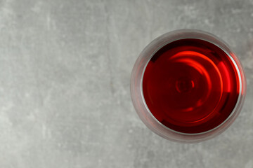 Glass of red wine on gray textured background