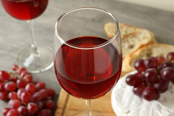 Concept of tasty eating with red wine on gray textured table