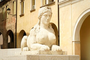 View of a stone sphinx statue in Conegliano, Italy.  Old sculpted female figure.  Tourism in Veneto Region and European travel experience.