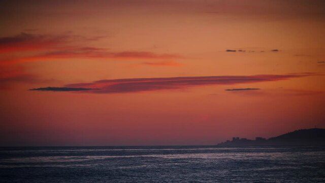 Red orange sky after sunset over sea. Nature, coastal landscape. Capi Corb, Mediterranean coast of Spain.