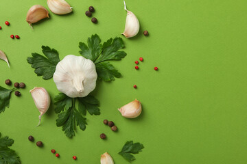 Garlic, parsley and spices on green background