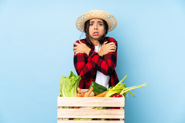 Young farmer Woman holding fresh vegetables in a wooden basket freezing