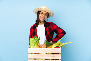 Young farmer Woman holding fresh vegetables in a wooden basket with glasses and smiling