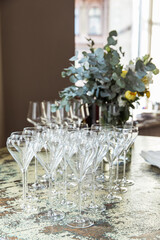 Rows of shiny empty high glasses with reflections in restaurant. Catering concept. Set of blank empty wine glasses displayed in rows. Preparation for the holiday
