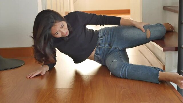 woman falling from staircase and getting injured with knee pain or broken leg bone