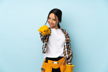 Young electrician woman isolated on blue background points finger at you with a confident expression