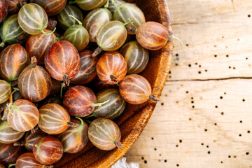 Red gooseberries on a wooden table.