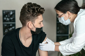 Young man has given injection in the shoulder. coronavirus vaccine. Vaccination against coronavirus. Selective focus.