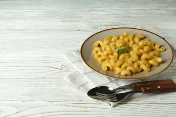 Concept of tasty eating with macaroni with cheese on wooden background
