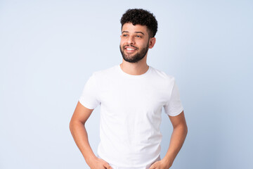 Obraz premium Young Moroccan man isolated on blue background thinking an idea while looking up