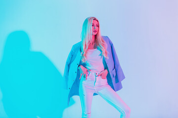 Fashionable beautiful business girl in white stylish glamour outfit with blue blazer on pastel...