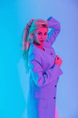 Stylish blonde beauty model woman with fashion elegant colored blazer with neon pink light blonde in the studio