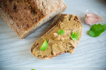 homemade liver pate with bread on a wooden table