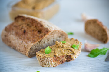 homemade liver pate with bread on a wooden table