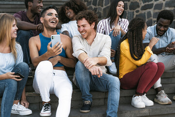Young multiracial group of friends using mobile smartphone sitting on stairs - Youth millennial...