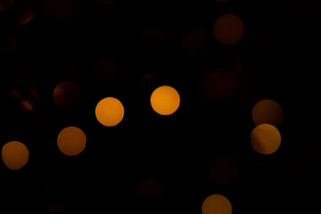Modern black background with illuminated out of focus lights. Yellow, Red and orange. 