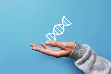 A person holds a DNA chain in his hand. A symbol of research and prevention of genetic diseases