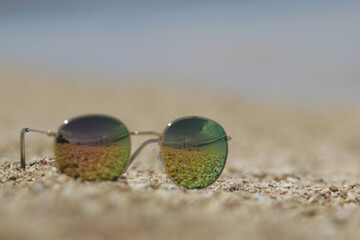 Fototapeta na wymiar Defocused abstract background of sunglasses on sands in the beach with sky and seascape view reflection. Summer concept stock images